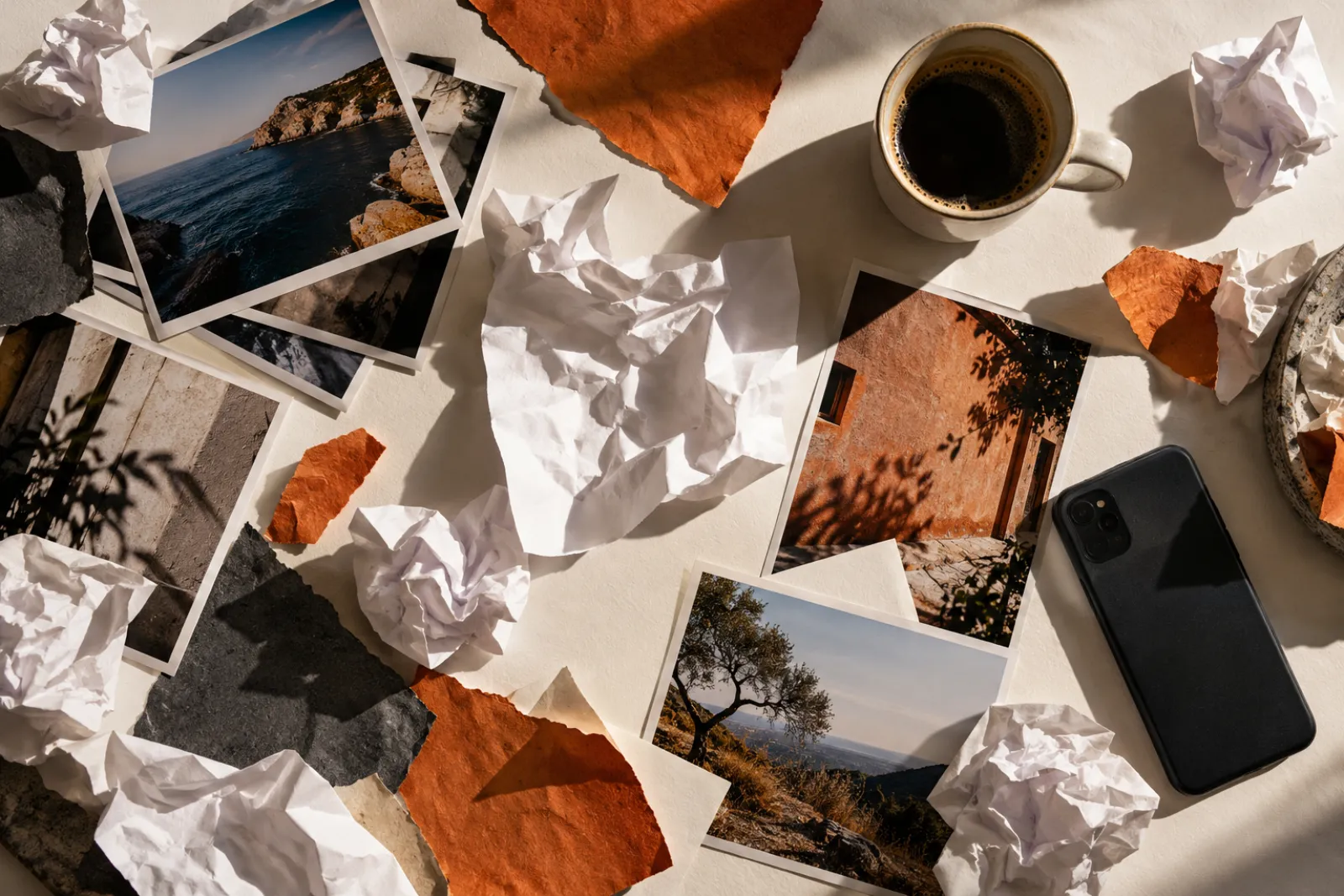 Antes: mesa vista de cima com fotos soltas, papéis amassados e recortes espalhados